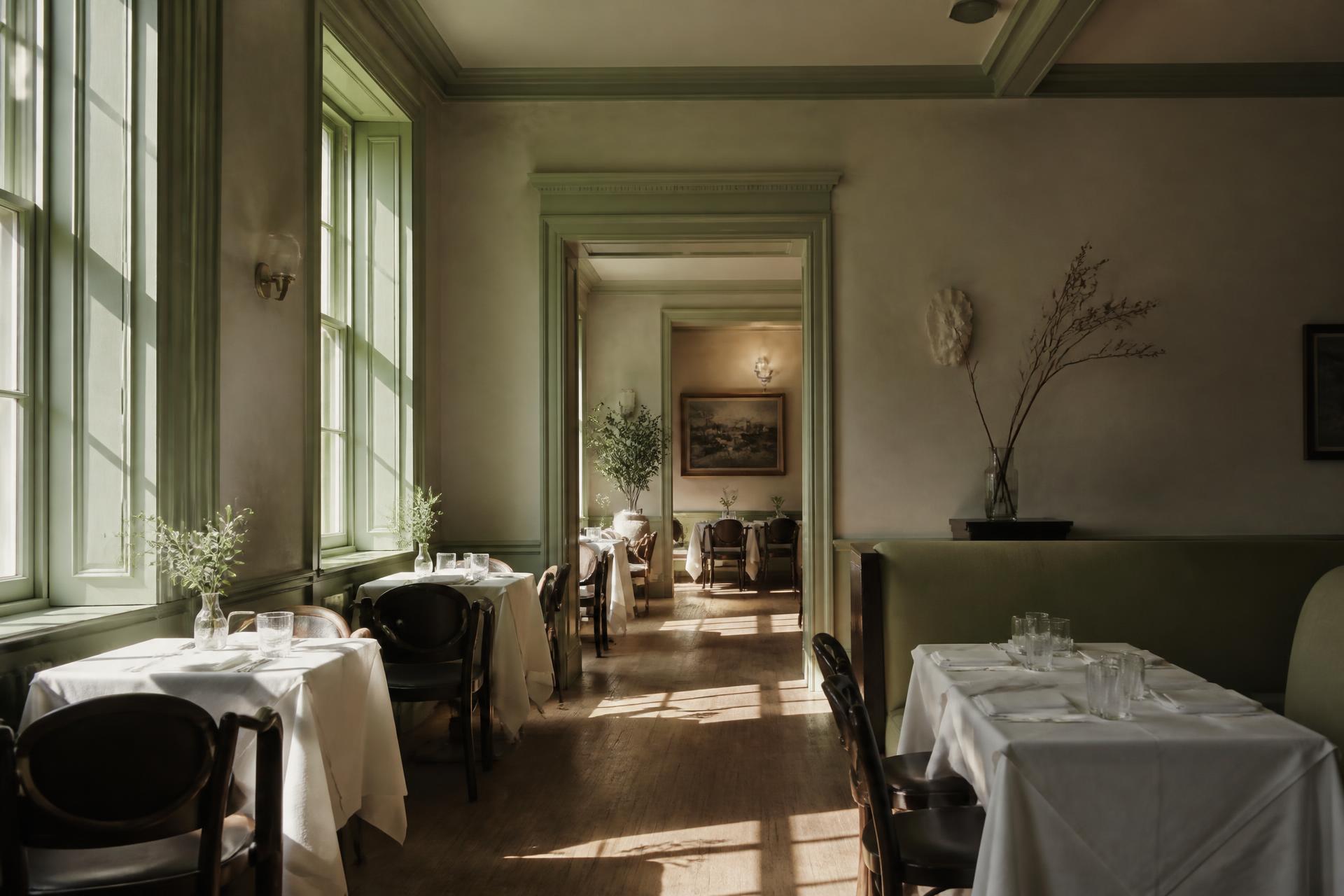 Comedor de un restaurante elegante con luz natural entrando por los ventanales